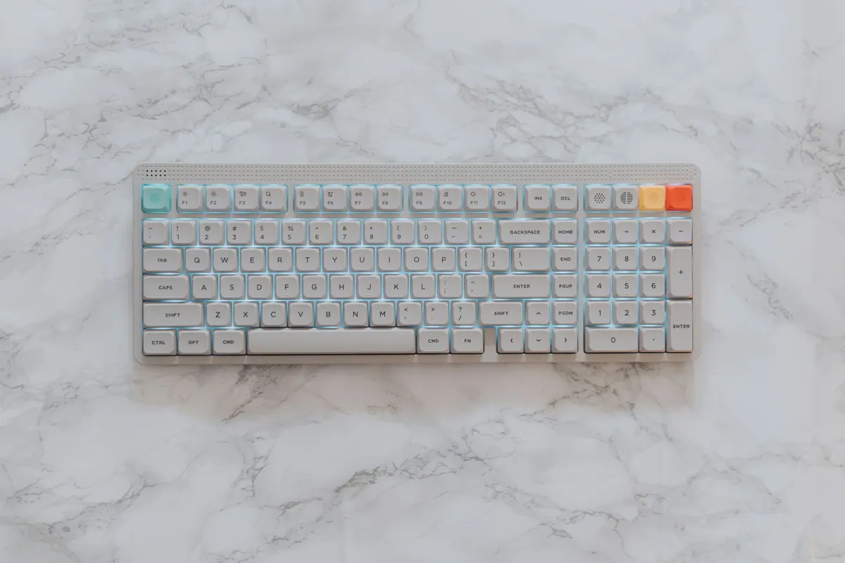 A light-colored mechanical keyboard on a marble surface