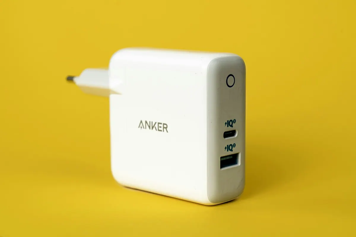 White power adapter photographed on a yellow surface