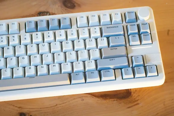 Close view of a cream-colored keyboard on a wooden desk